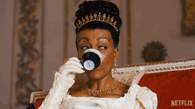 a woman in a white dress is drinking from a cup with a netflix logo on the bottom