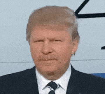 a close up of a man in a suit and tie with a mustache .