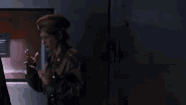 a woman in a military uniform is standing in front of a door