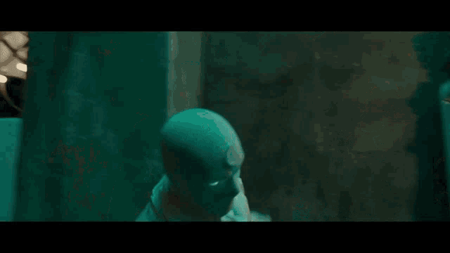 a person wearing a mask with glowing eyes is standing in a room .