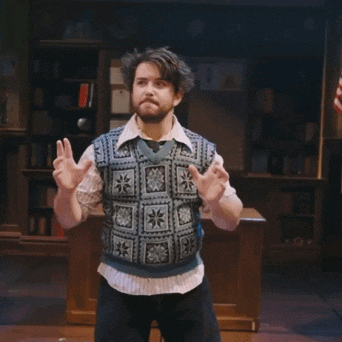a man with a beard wearing a sweater vest is dancing