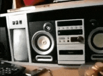 a row of speakers are sitting on top of a table next to a remote control .