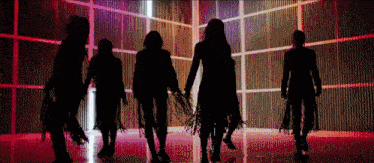 a group of women are standing in a dark room