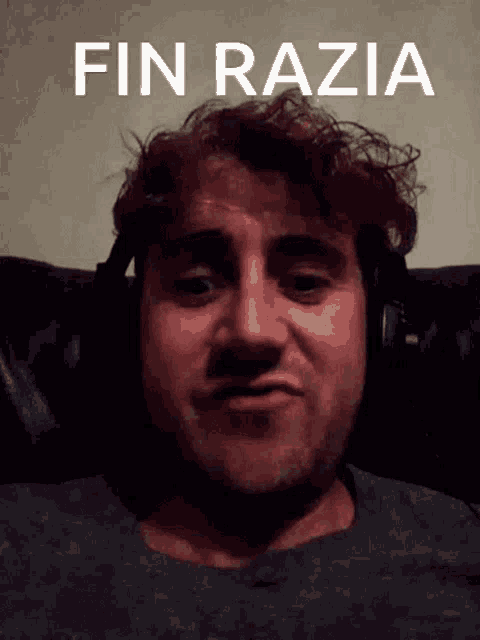 a man wearing headphones is sitting in front of a poster that says fin razia