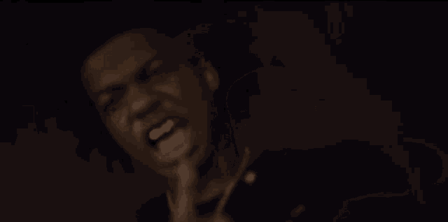 a close up of a man 's face with his hand outstretched