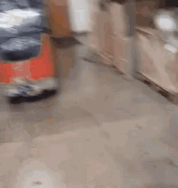 a blurry picture of a person walking down a hallway with boxes in the background .