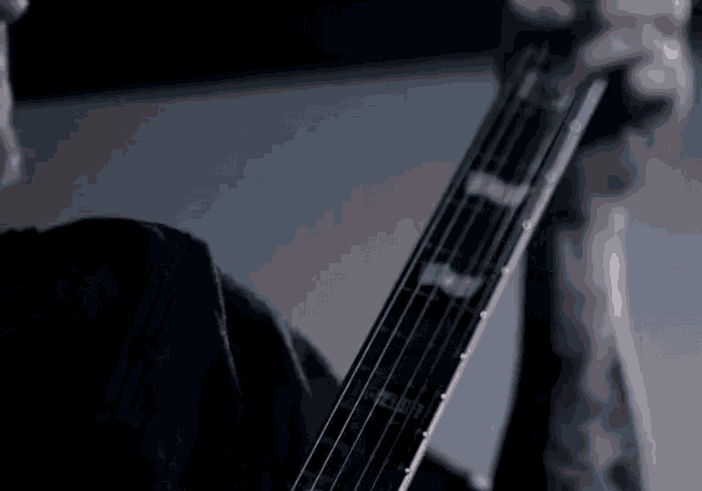 a man in a black shirt is playing an electric guitar .