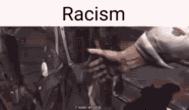 a person is pointing at a robot in a video game and the word racism is on the bottom .