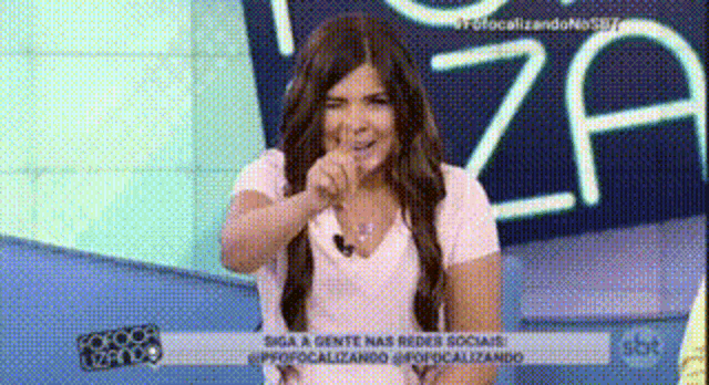 a woman making a funny face in front of a sign that says za