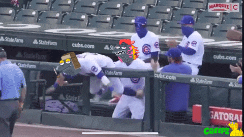 a group of cubs baseball players standing in a dugout
