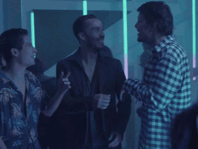 a group of men are dancing in a dark room with the words nuestra cancion in white letters