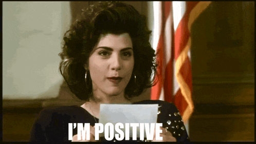 a woman holding a piece of paper that says i 'm positive on it