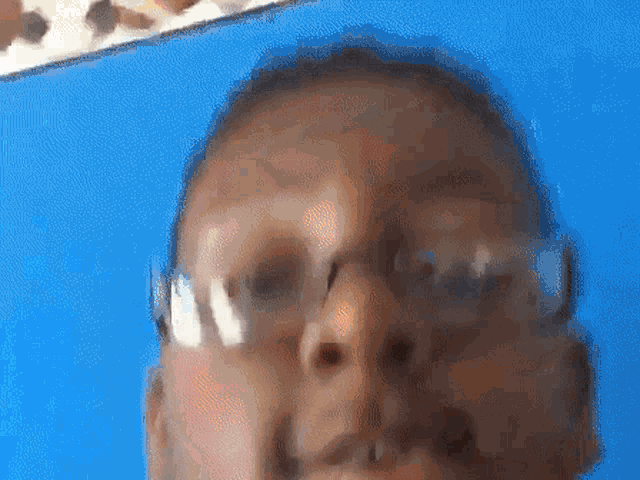 a blurry picture of a man 's face with glasses on