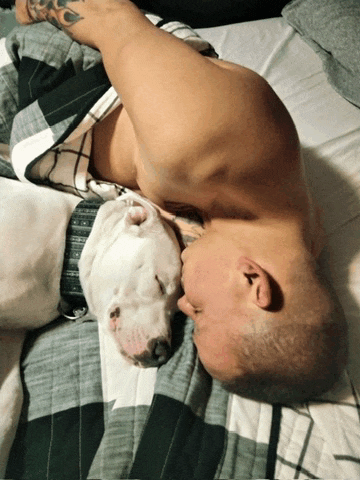 a man laying on a bed with a dog