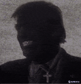 a man with a cross necklace around his neck is smiling