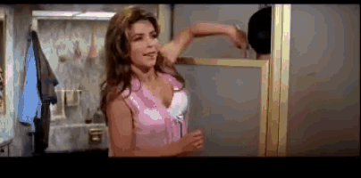 a woman in a pink top is standing in front of a glass shower door
