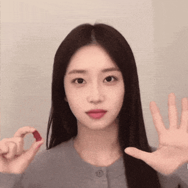 a woman with long hair is holding a small red object in her hand