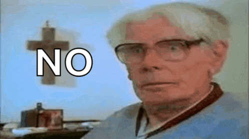 an elderly man wearing glasses says no in front of a cross on a wall .