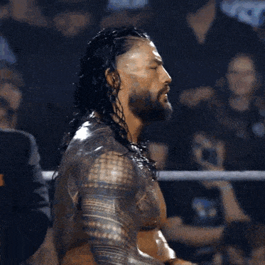 a wrestler with long hair and a tattoo on his arm
