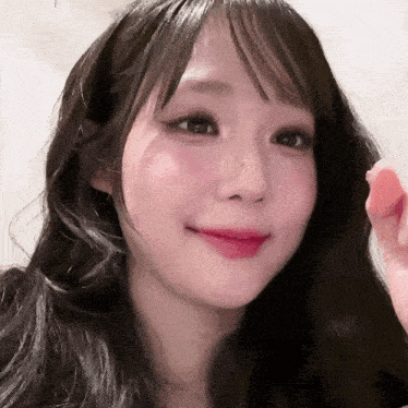 a close up of a woman 's face with long black hair and pink lips