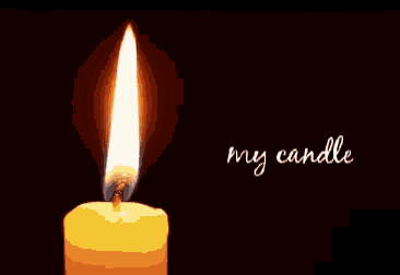 a close up of a yellow candle burning in the dark