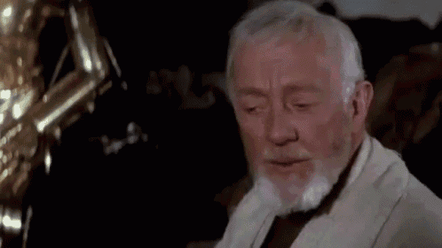 an older man with a beard is looking down at something