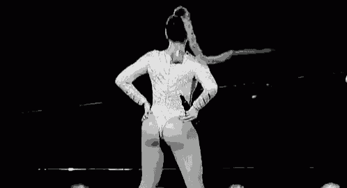 a black and white photo of a woman dancing on stage .