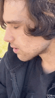 a close up of a man 's face with a beard and long hair .
