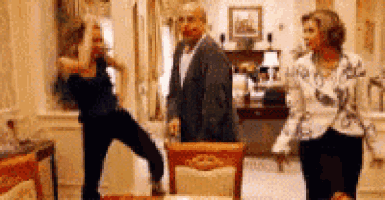 a group of people are dancing in a room .