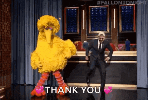 a man in a suit and tie is dancing next to a big bird costume .