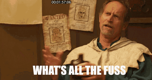 a man with a beard is standing in front of a wall with wanted posters on it