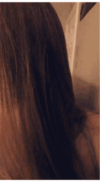 a close up of a woman 's hair with a door behind her