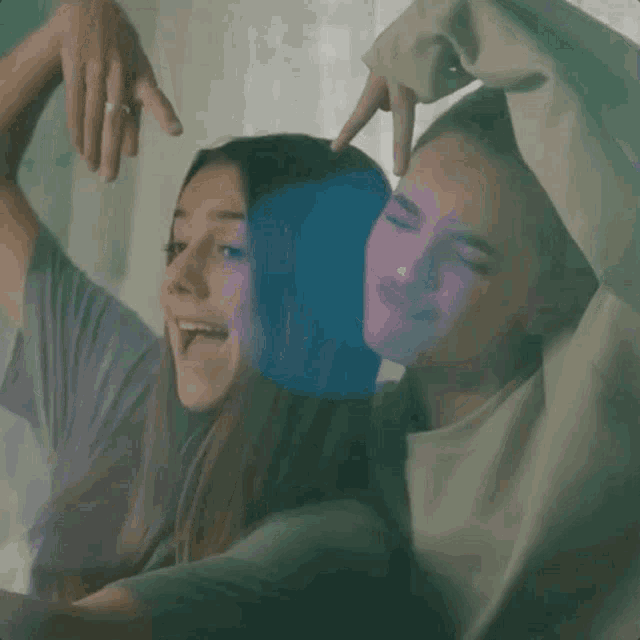 a couple making a heart shape with their fingers