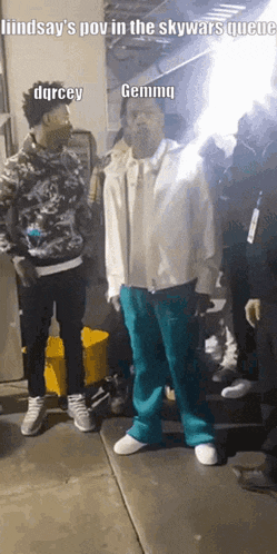 a group of men are standing in a queue and one of them is wearing a white jacket and blue pants