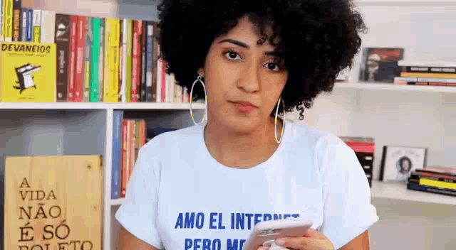 a woman with curly hair is wearing a white t-shirt that says amo el internet