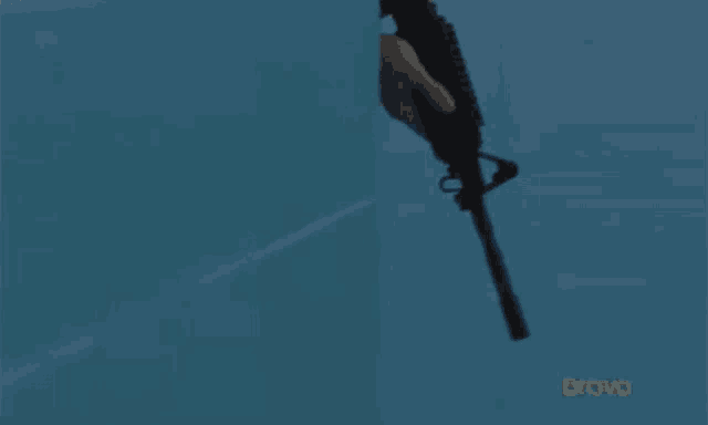 a man in a police uniform is holding a gun and shouting