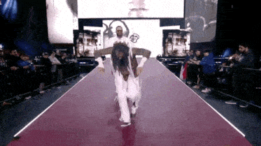 a man is carrying another man on his shoulders down a runway