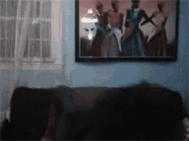 a painting of three women is hanging on the wall above a couch .
