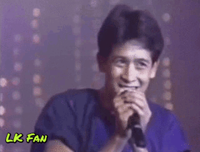 a man singing into a microphone with lk fan written in yellow