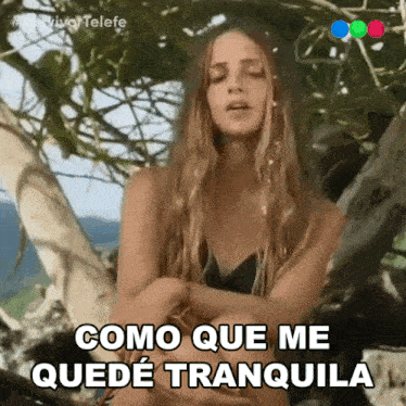 a woman sitting in a tree with the words como que me quede tranquila written below her