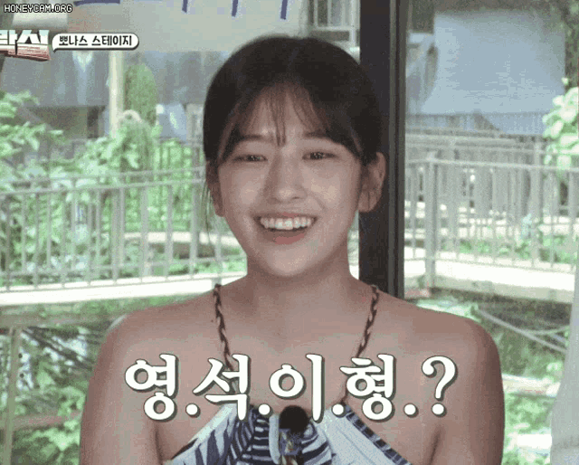 a woman without a shirt is smiling and asking a question in a foreign language