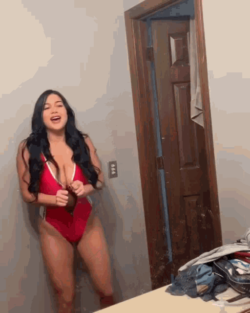 a woman in a red swimsuit is standing in a room
