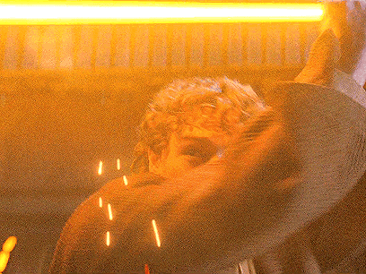 a close up of a person 's face with a yellow light behind him