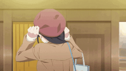a girl wearing a beret and a brown jacket is holding a bag with a heart on it