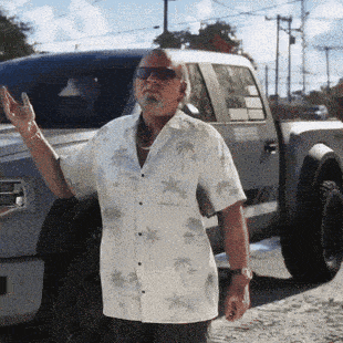 a man in a white shirt with palm trees on it