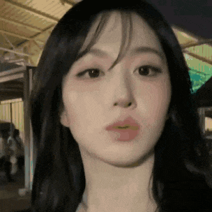 a close up of a woman 's face with her mouth open and a blurred background .