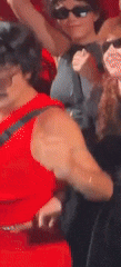 a man in a red tank top is standing next to a woman in sunglasses