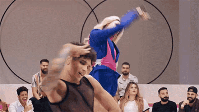 a group of people are watching a drag queen perform a dance in front of a crowd .