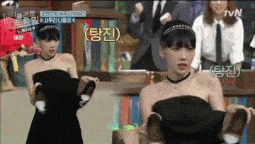 a woman in a black dress is standing in front of a tv screen