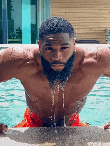 a shirtless man with a beard is in a pool of water